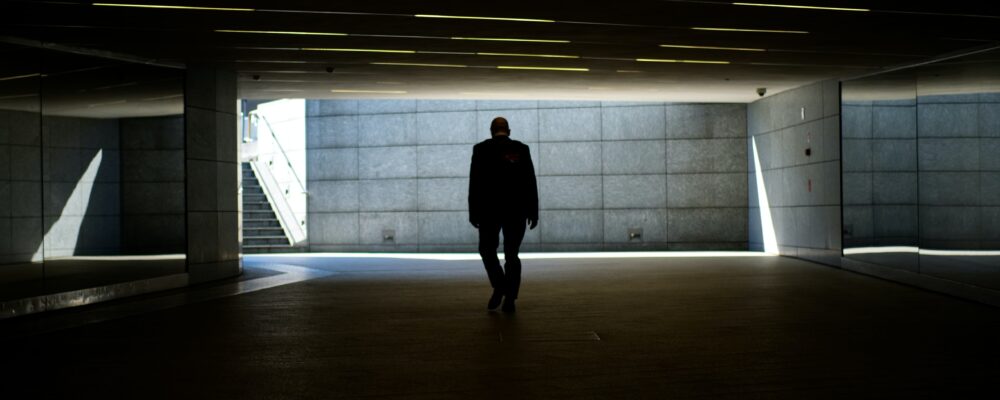 silhouette photo of person walking inside dark room