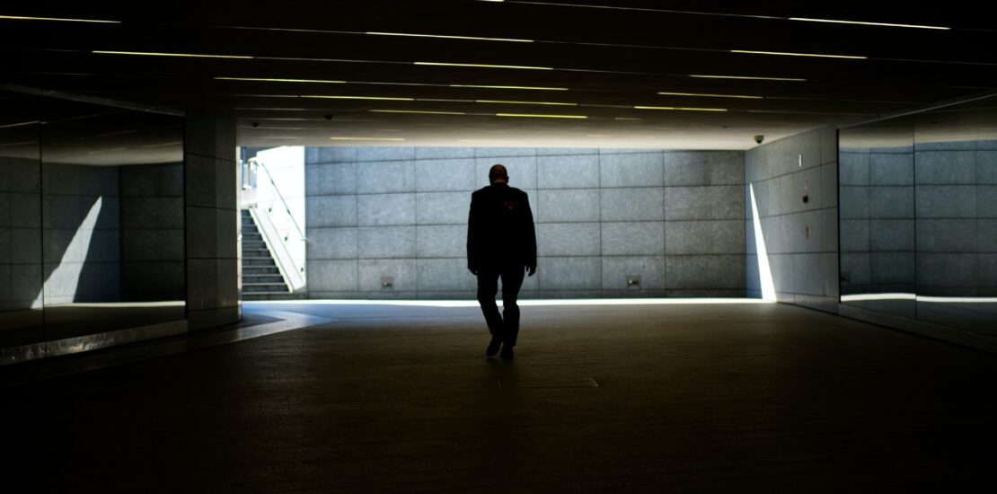 silhouette photo of person walking inside dark room